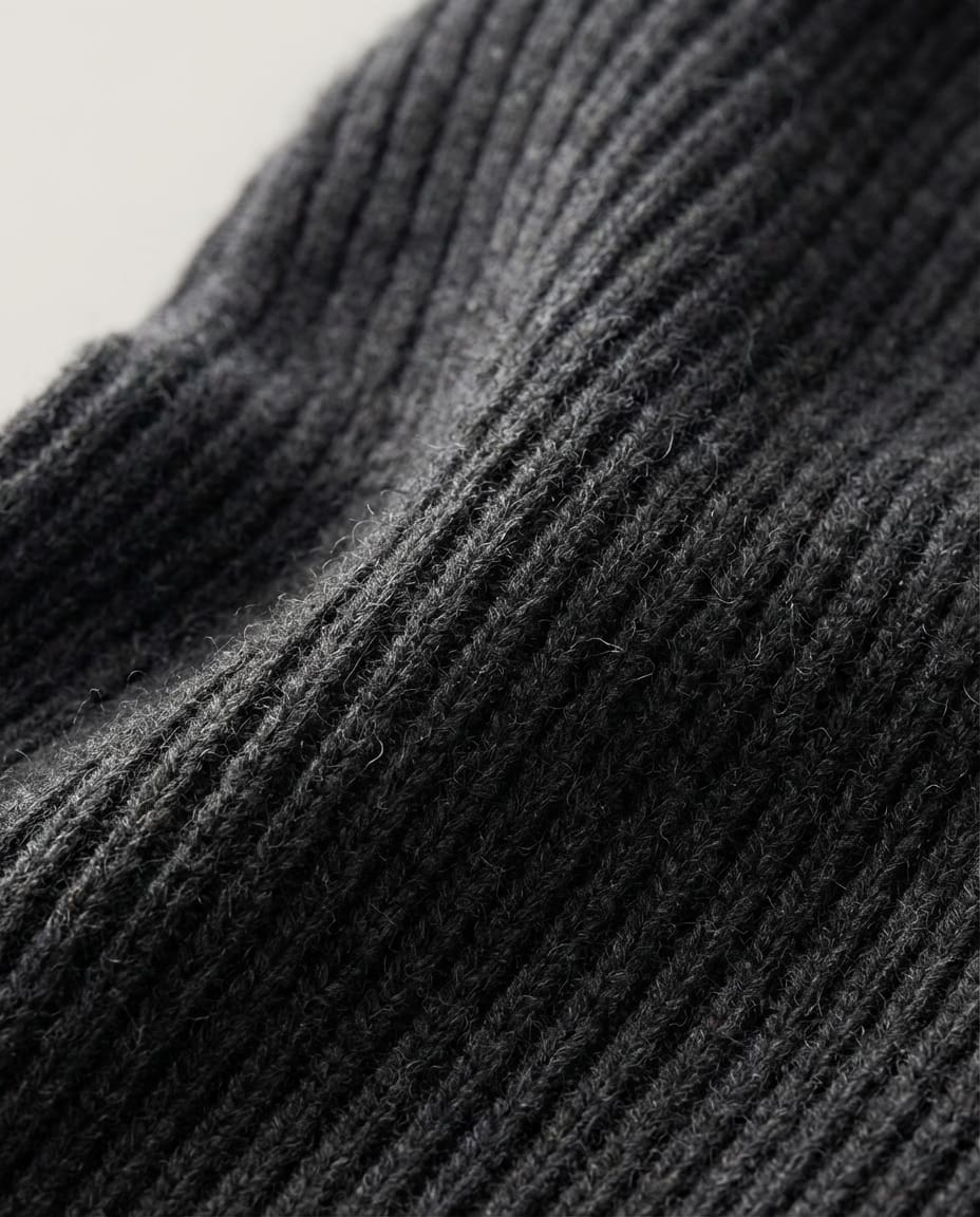 Hand lifting the front of the wool hood to show the face opening shape