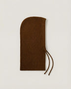 Wool hood folded flat for storage — still life on cream linen