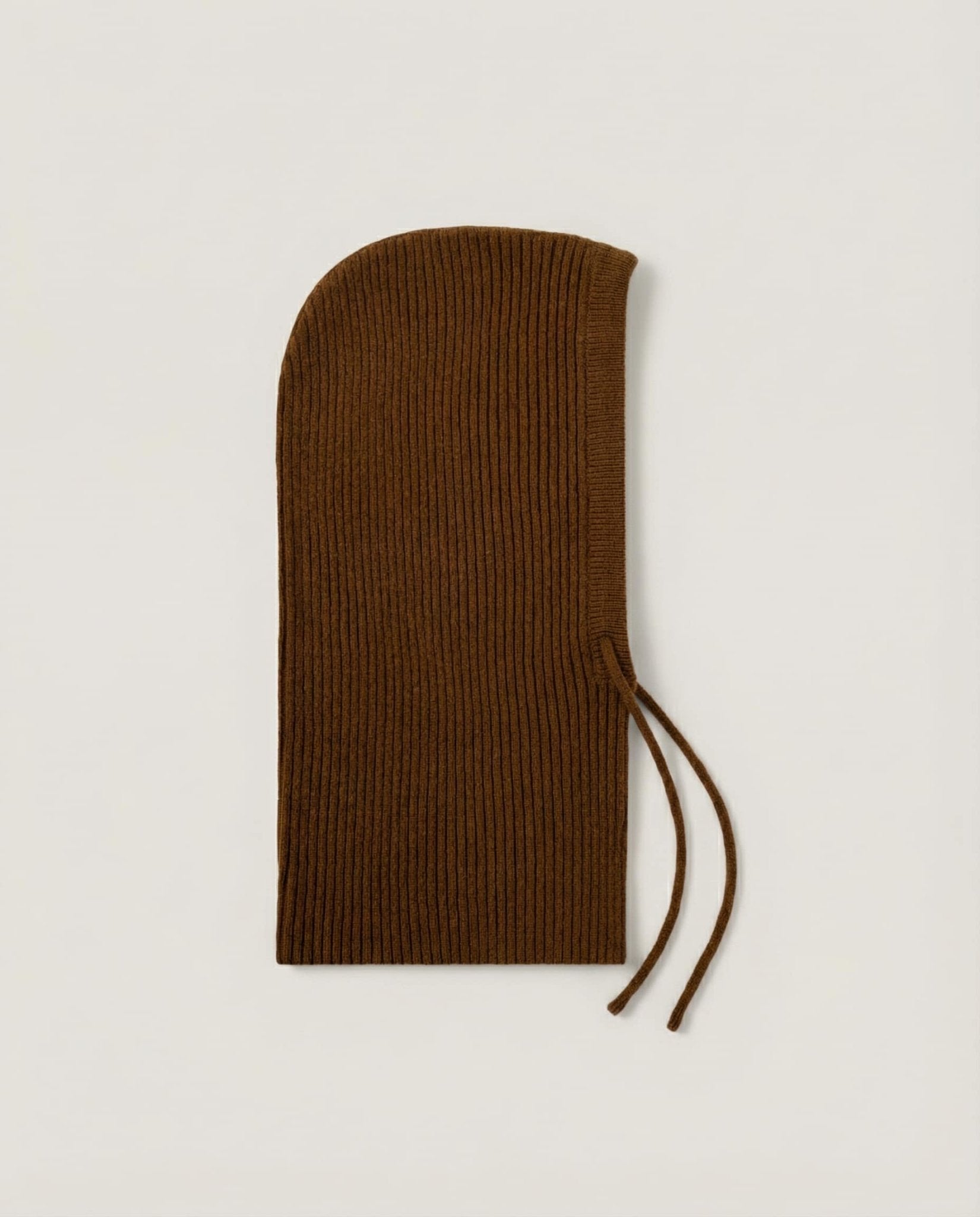 Wool hood folded flat for storage — still life on cream linen