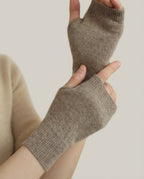 Hand wearing Wildfool fingerless glove holding a ceramic mug — warmth detail