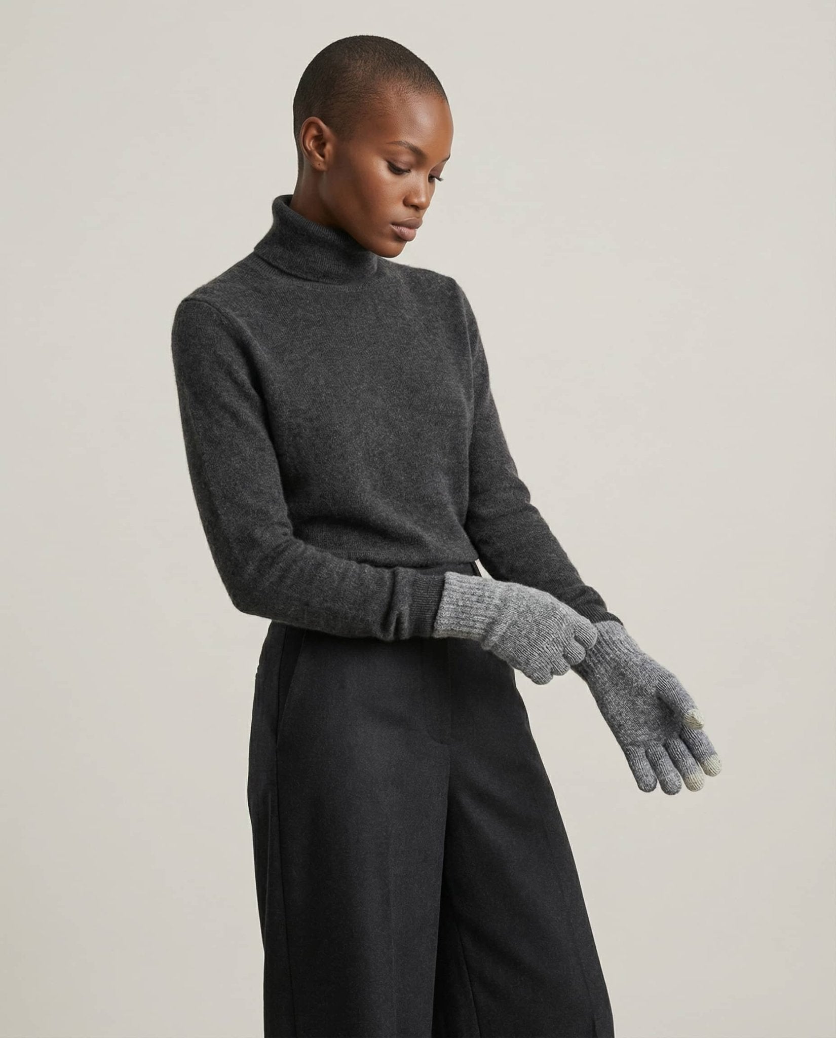 Hand in Wildfool tech glove tapping a phone screen — close-up finger detail