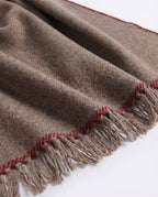 Wrap used as a travel blanket over the lap on an airplane seat — lifestyle shot