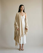 Blanket-wrap draped over the shoulders like a cape — three-quarter portrait outdoors