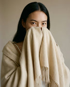 Wildfool nomad lambswool blanket-wrap in charcoal — full flat lay on a leather sofa