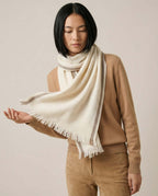 Herringbone scarf worn tucked inside a coat collar — front portrait in morning light