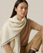 Wildfool herringbone lambswool scarf in oat with contrast edge — flat lay on cream linen