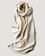 Scarf draped loosely over a blazer lapel — office styling shot
