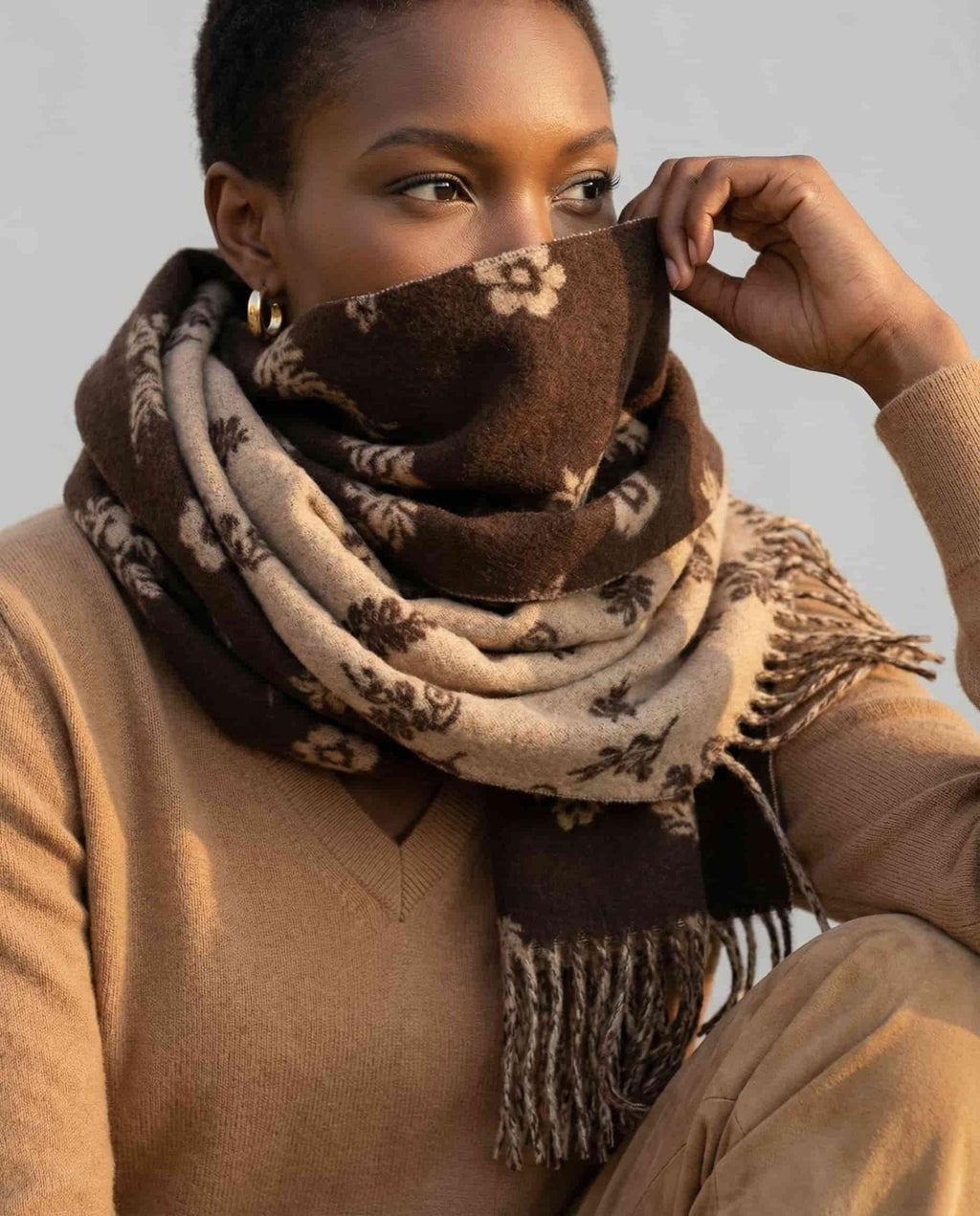 Hand folding back the scarf to reveal both sides of the reversible pattern