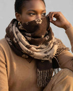 Hand folding back the scarf to reveal both sides of the reversible pattern