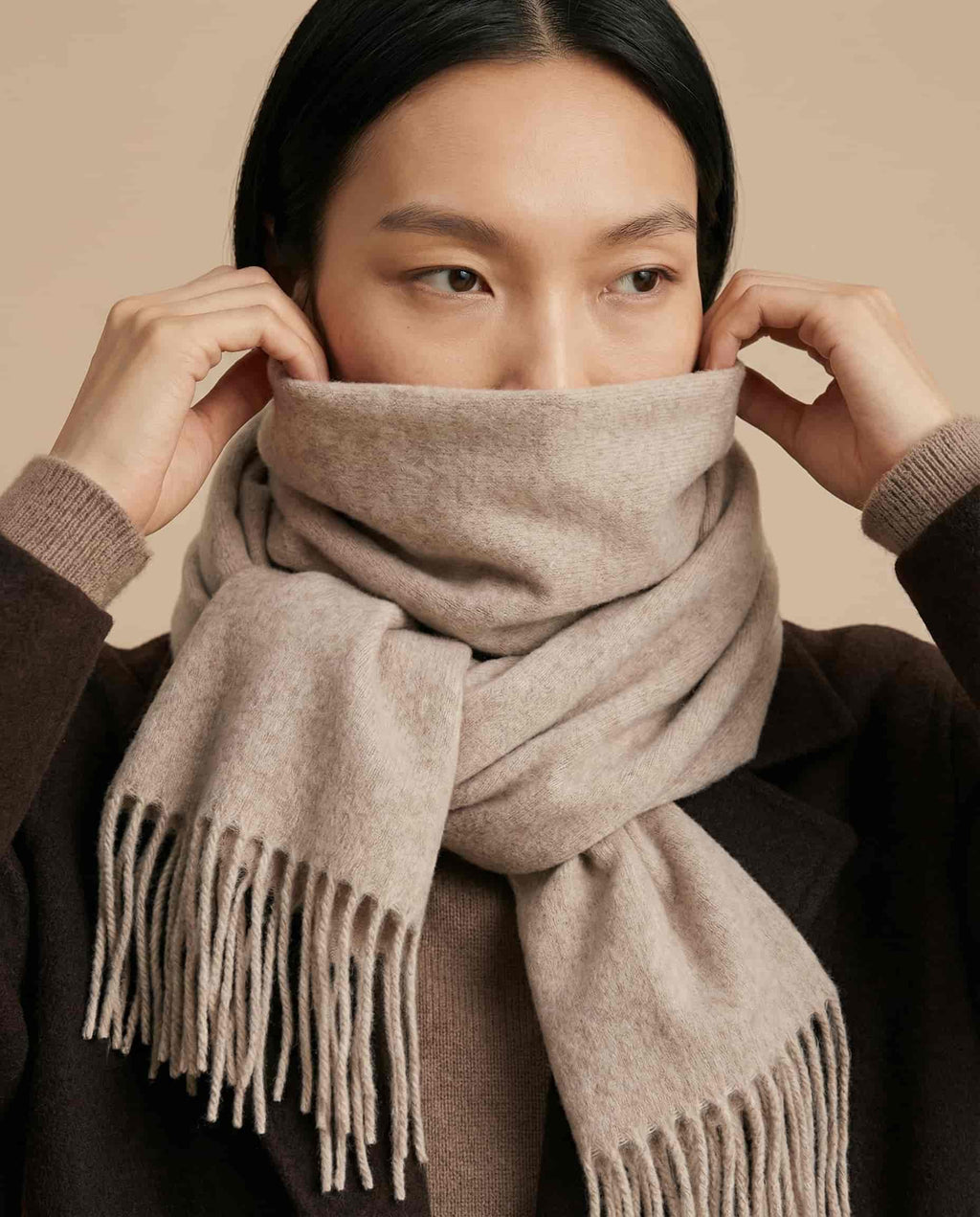 Scarf worn loose and long over a lightweight jacket — spring transition styling
