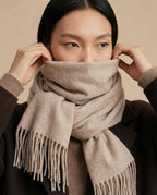 Scarf worn loose and long over a lightweight jacket — spring transition styling