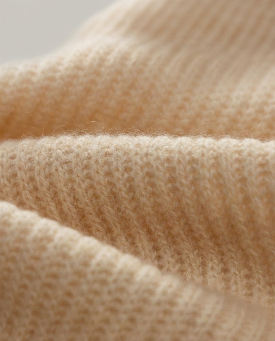 Hand demonstrating the slim fold of the cashmere collar — anti-bulk detail