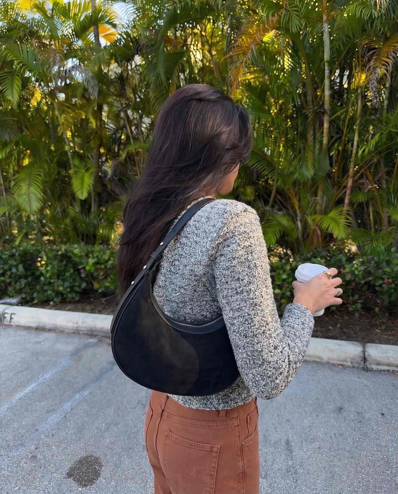 The Cassis Crescent Bag in Black, styled